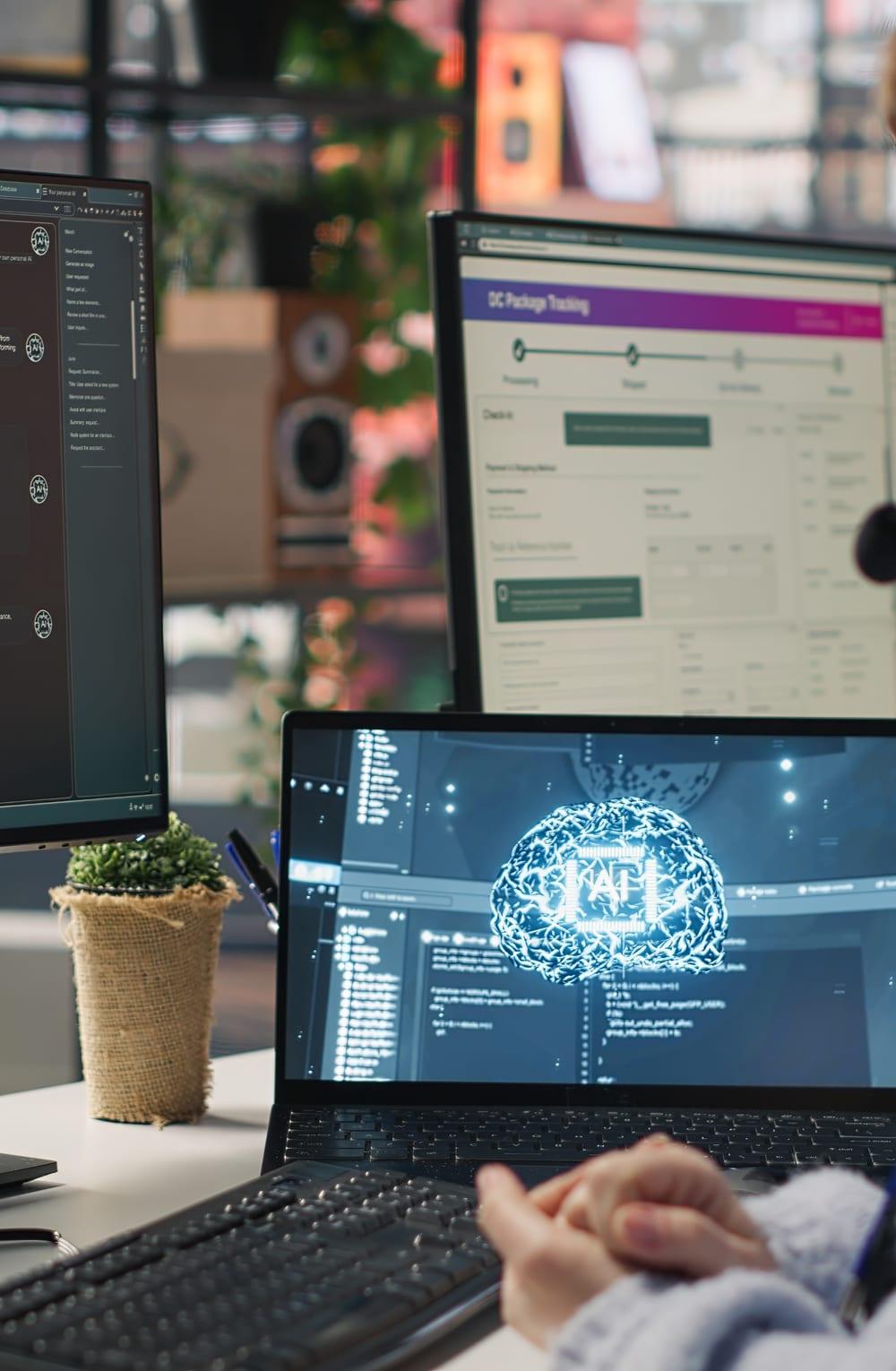 Developer working across multiple screens with an AI neural-network visualization on a laptop