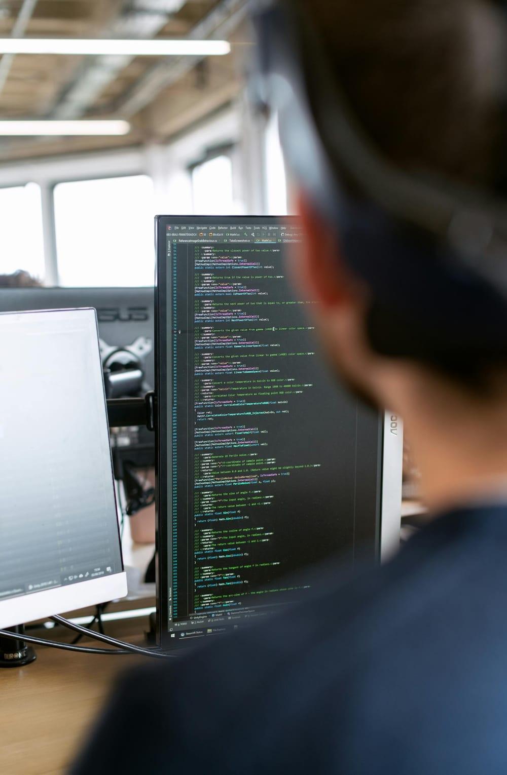 Engineer writing source code on a large monitor in a development studio